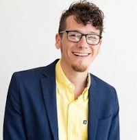 a man wearing glasses and a yellow shirt